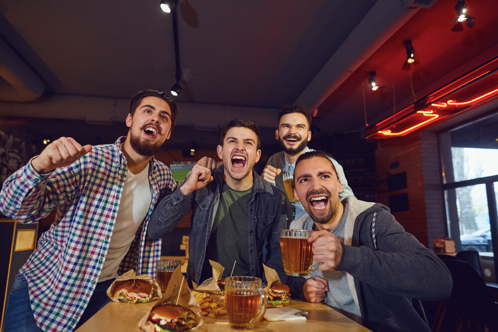 Friends fans watch sport tv in the pub